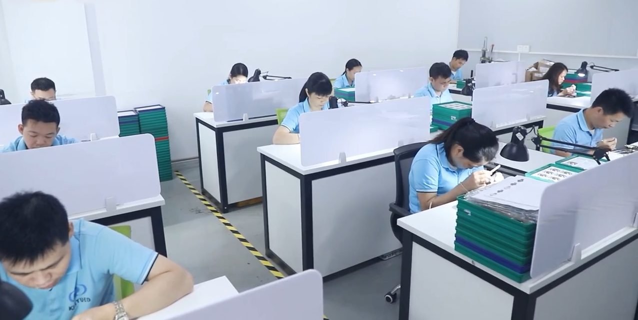 KINYUED production team working at assembly desks